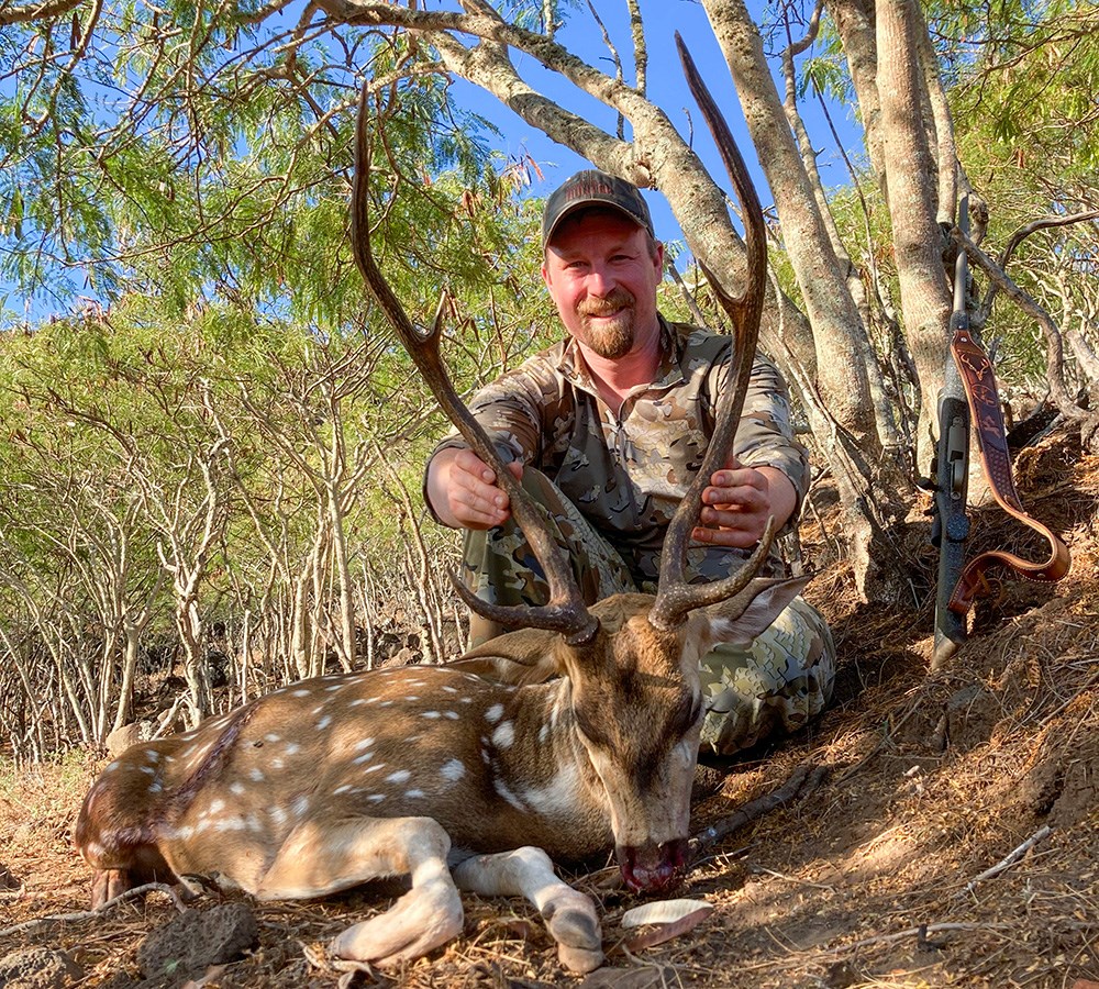 Hunter posing with axis deer shot on Hawaiian Island Molokai.