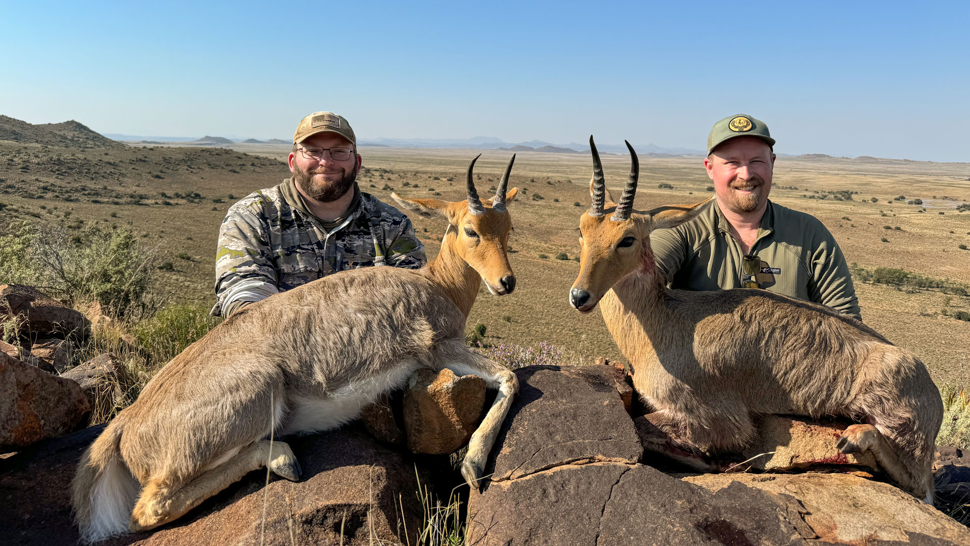 The author, right, and Shawn Skipper shot their mountain reedbuck in the rocky cliffs shortly before Skipper set up on his red lechwe on the flats below. The author, right, and Shawn Skipper shot their mountain reedbuck in the rocky cliffs shortly before Skipper set up on his red lechwe on the flats below.