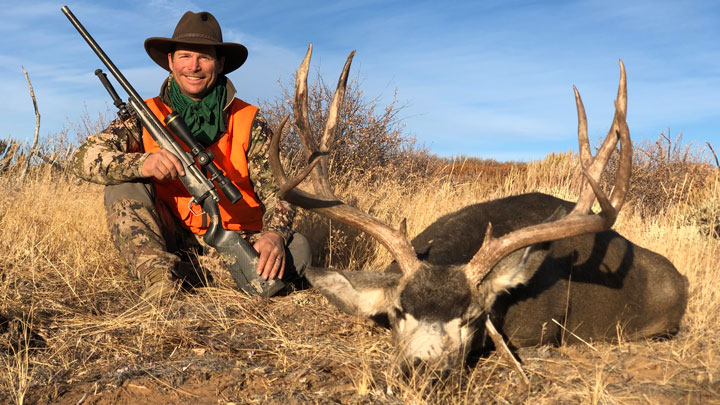 Hunter with dead mule deer