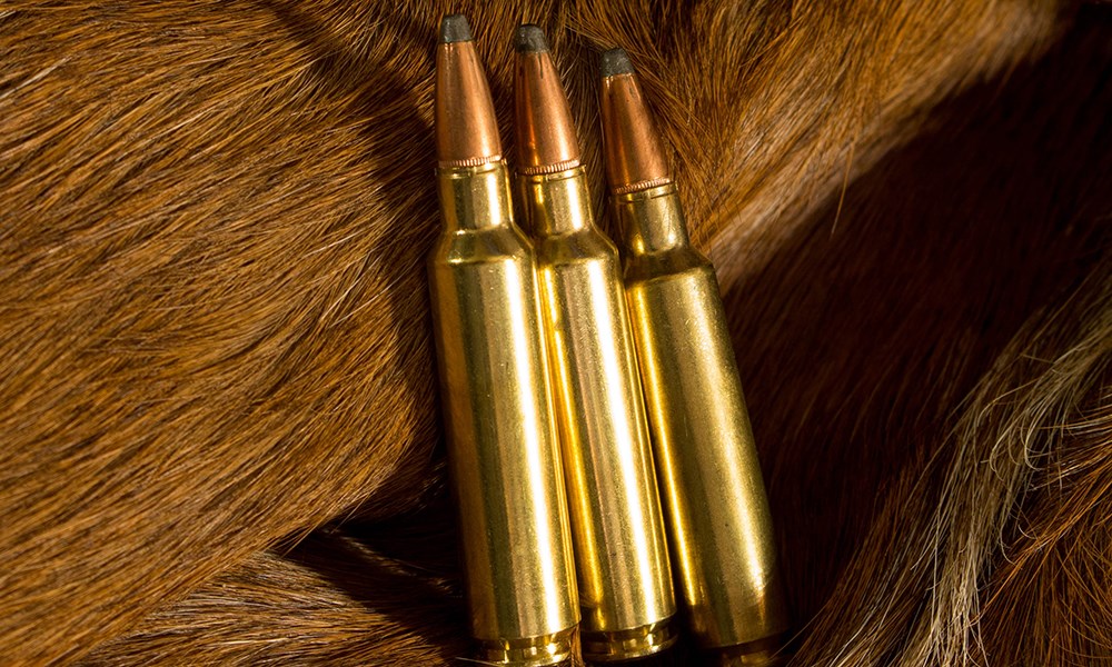 Three .284 Winchester cartridges laying on deer hide.