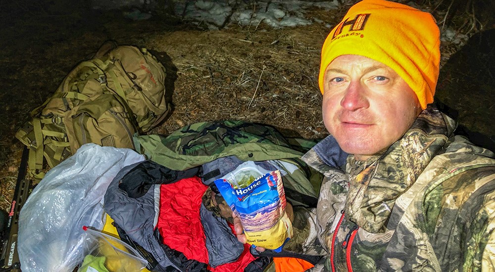 Male hunter wearing camouflage eating Mountain House packaged food.