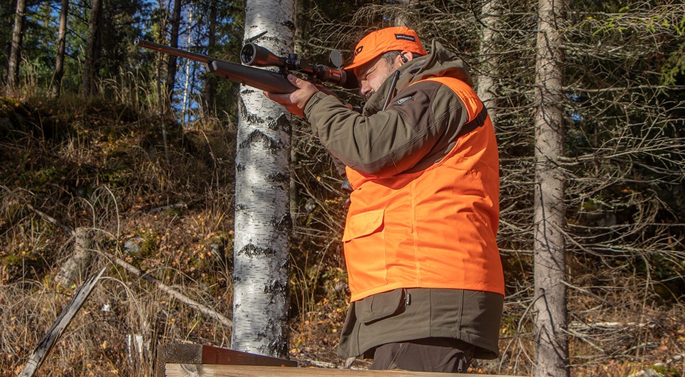 Male hunter shooting rifle in Finnish woods.