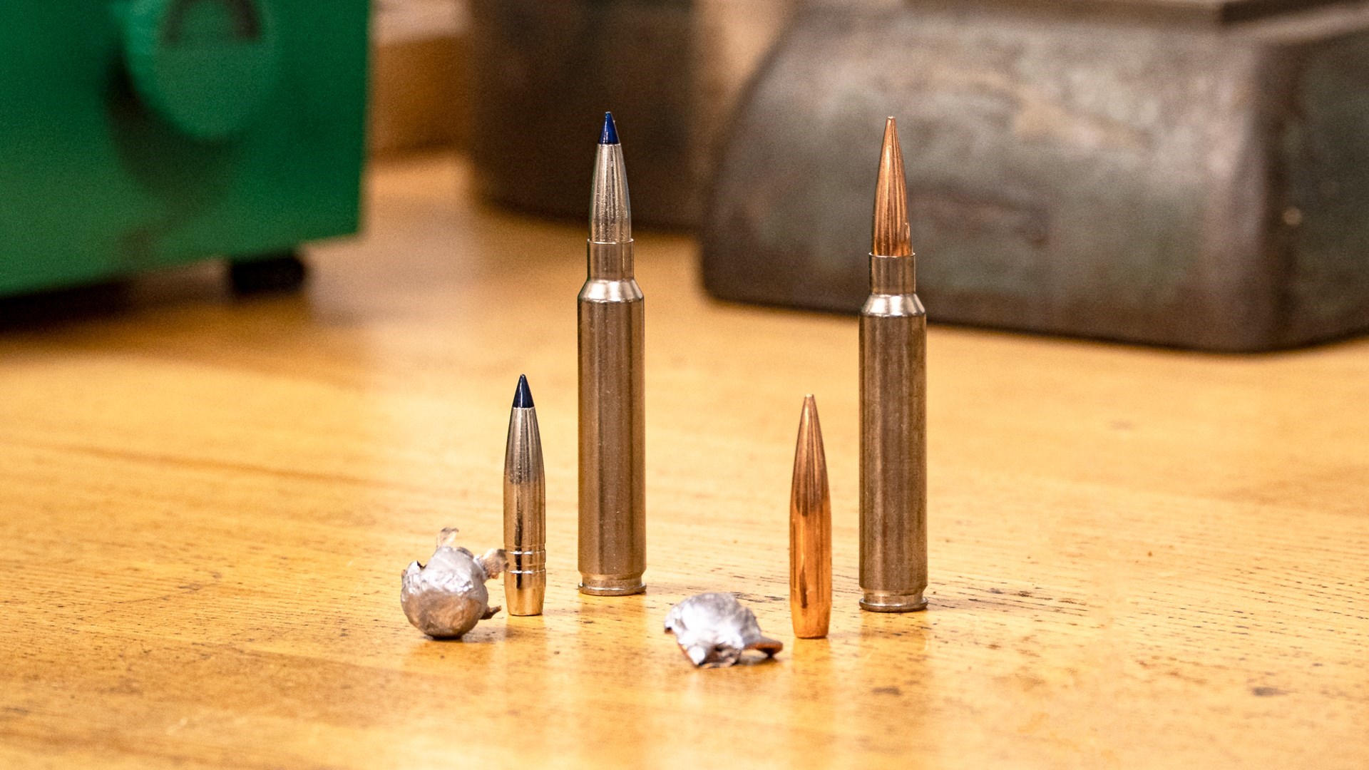 7mm Backcountry brass ammunition on wood table upright with respective bullets and expanded lead