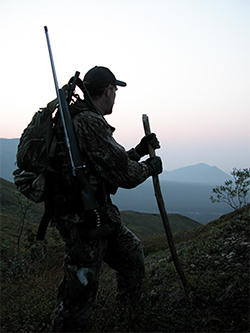 Hunter climbing steep mountain in Alaska