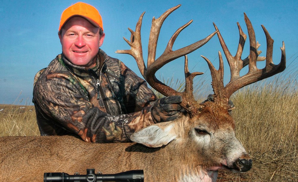 Hunter with giant Boone and Crockett whitetail non-typical buck.