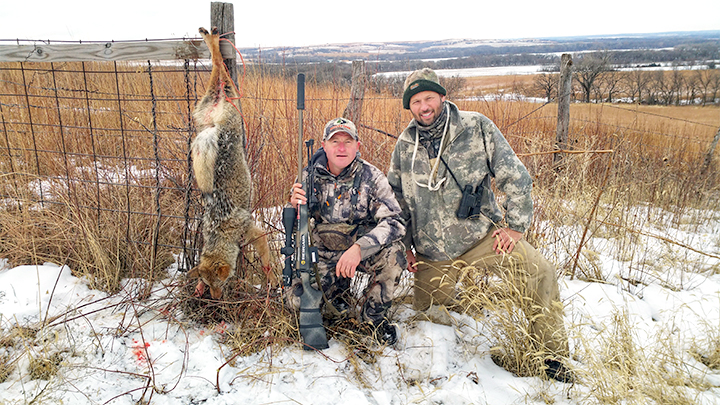 Two hunters with coyote