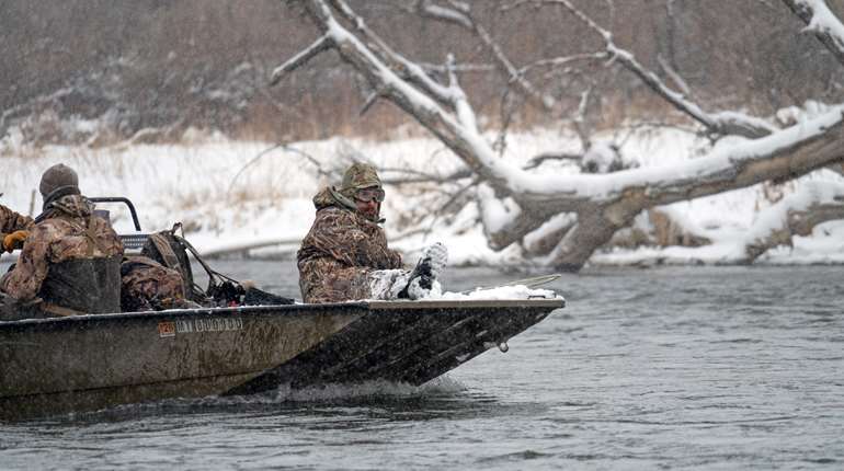 Camo jet boat on river snow men in boat camo cold